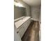 Modern bathroom with granite vanity, gray tiled walk-in shower, and wood look flooring at 24202 Nw Aspen Ln, Dunnellon, FL 34432