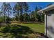 Spacious backyard with lush green grass and mature trees, perfect for outdoor activities at 9085 Sw 202Nd Avenue Rd, Dunnellon, FL 34431