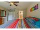 Inviting bedroom with ceiling fan, carpet, colorful linens, en-suite bathroom, and plentiful storage at 9085 Sw 202Nd Avenue Rd, Dunnellon, FL 34431