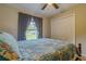 Inviting bedroom featuring carpet, a ceiling fan, a bed with blue linens, and an outdoor view at 9085 Sw 202Nd Avenue Rd, Dunnellon, FL 34431