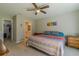 Comfortable bedroom featuring carpet, a ceiling fan, a bed with colorful linens, and an en-suite bathroom at 9085 Sw 202Nd Avenue Rd, Dunnellon, FL 34431