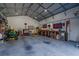 Spacious garage featuring a workbench, storage, and a garage door at 9085 Sw 202Nd Avenue Rd, Dunnellon, FL 34431