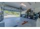 Spacious two-car garage with an open door, ample storage shelves, and a clean concrete floor at 9085 Sw 202Nd Avenue Rd, Dunnellon, FL 34431