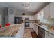 Open kitchen with white cabinets, stainless steel appliances, and granite countertops at 9085 Sw 202Nd Avenue Rd, Dunnellon, FL 34431