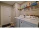 Efficient laundry room with a washer, dryer, utility sink, and storage shelves at 9085 Sw 202Nd Avenue Rd, Dunnellon, FL 34431