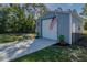 Exterior of outbuilding with a garage door and a parking area, complemented by US flags at 9085 Sw 202Nd Avenue Rd, Dunnellon, FL 34431