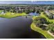 Expansive aerial shot of a golf course community featuring a serene lake with a walking path bridge at 2960 Boating Blvd, Kissimmee, FL 34746