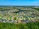 Aerial view of a meticulously planned community, featuring beautiful homes encircling a serene lake and verdant landscaping at 2960 Boating Blvd, Kissimmee, FL 34746