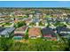 Aerial view highlighting homes with screened-in pools, in a neighborhood with a tranquil lake and lush greenery at 2960 Boating Blvd, Kissimmee, FL 34746