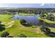 Scenic aerial view of lush golf course community with large pond and mature trees on a sunny day at 2960 Boating Blvd, Kissimmee, FL 34746