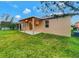 Green backyard featuring a covered patio, windows, and exterior home siding at 2960 Boating Blvd, Kissimmee, FL 34746