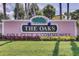Entrance sign to 'The Oaks' Golf Club and Community with manicured lawn and colorful landscaping at 2960 Boating Blvd, Kissimmee, FL 34746