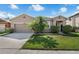 Inviting single-story home featuring a well-maintained lawn, beautiful palm tree, and attached garage at 2960 Boating Blvd, Kissimmee, FL 34746