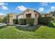 This home features a manicured lawn, trimmed hedges, an entry portico, and an attached two-car garage at 2960 Boating Blvd, Kissimmee, FL 34746