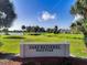Oaks National Golf Club sign, scenic golf course with mature trees and a tranquil pond in the background at 2960 Boating Blvd, Kissimmee, FL 34746