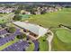Aerial view of clubhouse with parking, tennis courts, and lush green golf course at 2960 Boating Blvd, Kissimmee, FL 34746