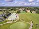 Aerial view of clubhouse, parking, tennis courts, and well-maintained green of the golf course at 2960 Boating Blvd, Kissimmee, FL 34746