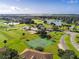 Wide aerial view of tennis court, golf course, clubhouse, ponds and road in a lush community at 2960 Boating Blvd, Kissimmee, FL 34746