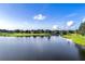 Expansive view of a serene pond bordered by green landscaping and mature trees under a clear sky at 2960 Boating Blvd, Kissimmee, FL 34746