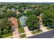 Aerial view of the property showcasing mature trees, a well-manicured lawn, and a paved driveway at 777 Summit Greens Blvd, Clermont, FL 34711
