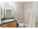 A full bathroom featuring a shower-tub combo, white tile, and a vanity with a large mirror and lighting at 777 Summit Greens Blvd, Clermont, FL 34711