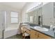 Bright bathroom with dual sinks, large mirror, and a separate tub and shower at 777 Summit Greens Blvd, Clermont, FL 34711