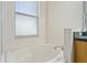 Bright bathroom showcasing a clean, white bathtub under a window with blinds at 777 Summit Greens Blvd, Clermont, FL 34711
