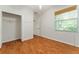 This bedroom has hard wood floors, a window with wood blinds, and a closet for ample storage space at 777 Summit Greens Blvd, Clermont, FL 34711