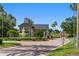 Well-manicured community entrance, with a water fountain, manicured hedges and palms, and a security entrance at 777 Summit Greens Blvd, Clermont, FL 34711