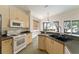Bright kitchen features light wood cabinets, neutral countertops, and modern appliances at 777 Summit Greens Blvd, Clermont, FL 34711