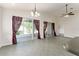 Open living room with sliding glass doors to the lanai, neutral tile floors, and modern chandelier at 777 Summit Greens Blvd, Clermont, FL 34711