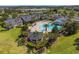 Aerial view of the community pool area surrounded by lush landscaping and recreational buildings at 777 Summit Greens Blvd, Clermont, FL 34711