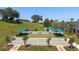 Aerial view of shuffleboard courts with sun shades, surrounded by green lawns and landscaping at 777 Summit Greens Blvd, Clermont, FL 34711