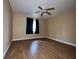 Simple bedroom featuring hardwood floors, ceiling fan, window, and neutral walls at 1925 Laredo Dr, Deltona, FL 32738