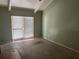 Bedroom with a sliding glass door and uncarpeted floors, with painted green walls and a white ceiling at 116 Wild Holly Ln, Longwood, FL 32779