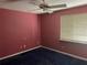 Bedroom with maroon walls, uncarpeted floors, a window, and a ceiling fan at 116 Wild Holly Ln, Longwood, FL 32779