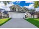 Traditional two-story home featuring a two-car garage, complemented by lush green lawn at 1839 Cranberry Isles Way, Apopka, FL 32712