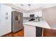 Modern kitchen features stainless steel refrigerator, white cabinets and white counters at 1839 Cranberry Isles Way, Apopka, FL 32712