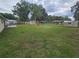 Wide view of large backyard featuring mature trees and playground equipment, perfect for recreation at 3509 Lisa Ln, Lakeland, FL 33801