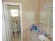 Bright bathroom with floral wallpaper, a toilet in separate enclosure and a vanity with a sink at 3509 Lisa Ln, Lakeland, FL 33801