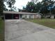 Single Gathering home with driveway and car port, blue shutters, brick accent and mature landscaping at 3509 Lisa Ln, Lakeland, FL 33801