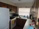 Kitchen features wood cabinets, white appliances and a large window for natural light at 3509 Lisa Ln, Lakeland, FL 33801
