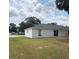 Spacious backyard of a charming single-story home with lush green lawn and a modern sliding glass door at 5356 Spivey Glen Ct, Lakeland, FL 33810