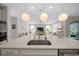 Close-up of the large kitchen island featuring a stainless steel sink, quartz countertop, and stylish pendant lighting at 6185 Sw 89Th Ct, Ocala, FL 34481
