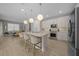 Bright kitchen with white cabinets, a large central island, stainless steel appliances, and a dining area at 6185 Sw 89Th Ct, Ocala, FL 34481