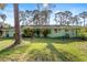 A quaint, single-story home with a spacious backyard and mature trees, providing privacy and shade at 641 Jackson St, Eustis, FL 32726
