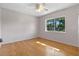 Cozy bedroom featuring hardwood floors, neutral wall paint, and natural light from a window at 641 Jackson St, Eustis, FL 32726
