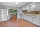 Updated kitchen featuring white cabinets, a mosaic backsplash, and modern appliances at 641 Jackson St, Eustis, FL 32726