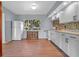 Bright kitchen featuring white cabinets, a mosaic backsplash, and a window overlooking a tree filled yard at 641 Jackson St, Eustis, FL 32726