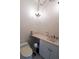 Cozy powder room featuring a pedestal sink, toilet, and decorative chandelier lighting fixture at 1695 Horseshoe Rd, Deltona, FL 32725